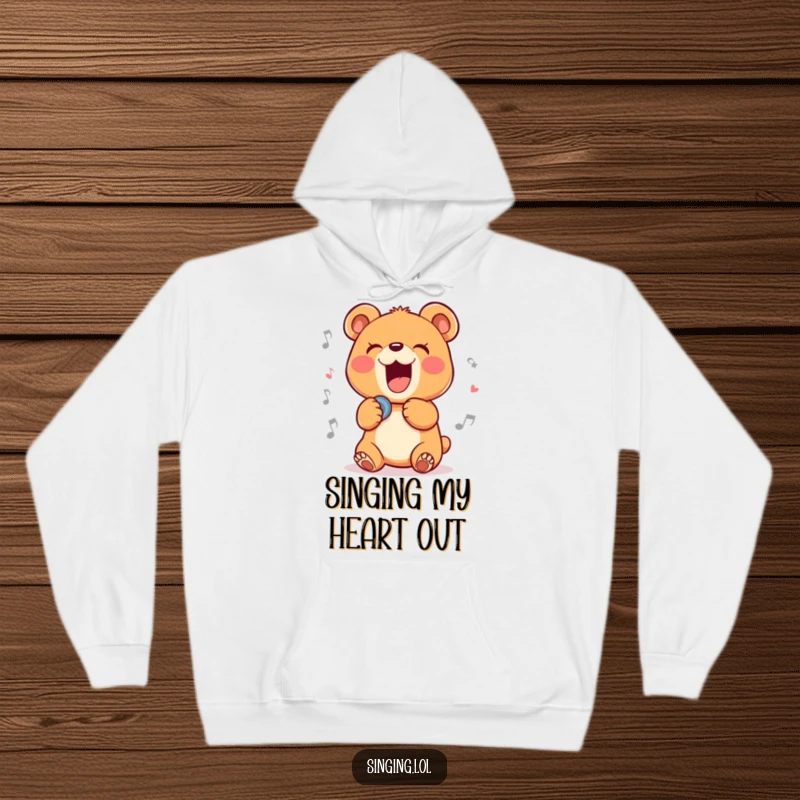 Funny hoodie showcasing a delighted bear cub character passionately belting out a ballad, perfect for cozy, musical moments.